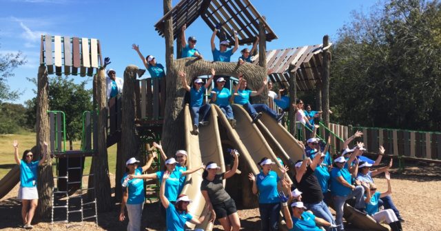 St. David's Foundation staff gather near the new playscape at dove springs park